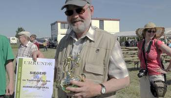 Unser, ein wenig stolzer, Ortsbürgermeister mit den Siegeruntensilien, Pokal und Urkunde