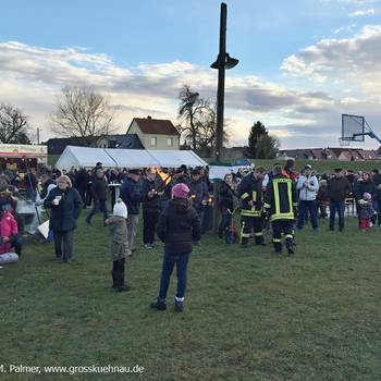 Die Fackeln zum Zünden des Feuers werden vorbereitet, Kameraden der Feuerwehr helfen dabei.